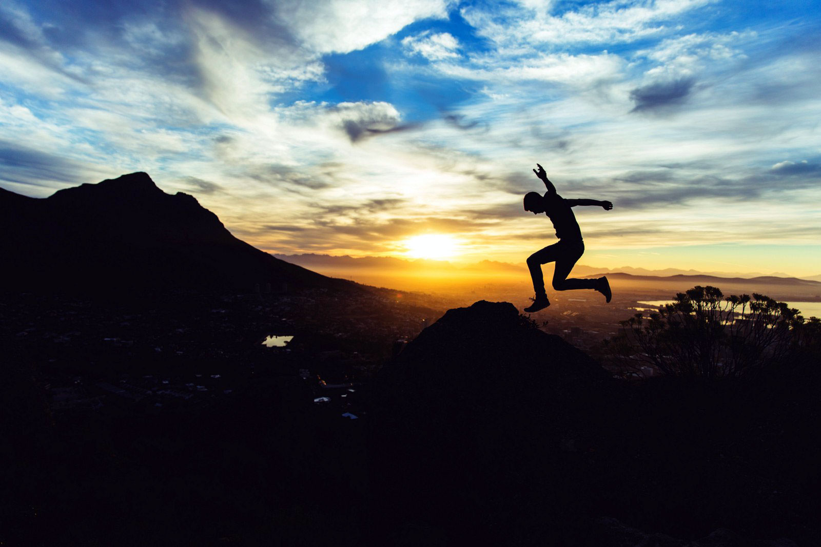 person jumping in front of sunset